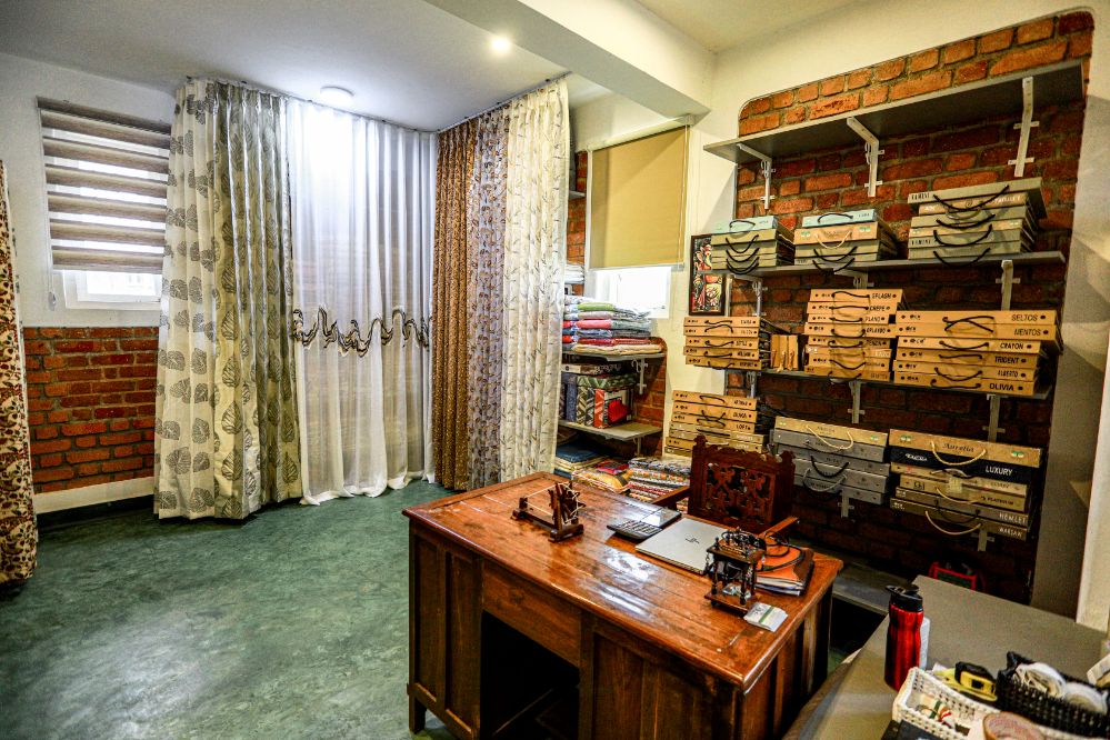 The Curtain Concepts showroom: fabric books on shelves above a wooden desk
