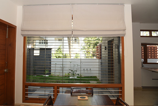 Off-white Roman blind over a dining-room window