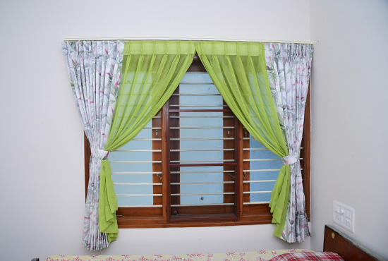 Lime green and white floral curtains framing a wooden window