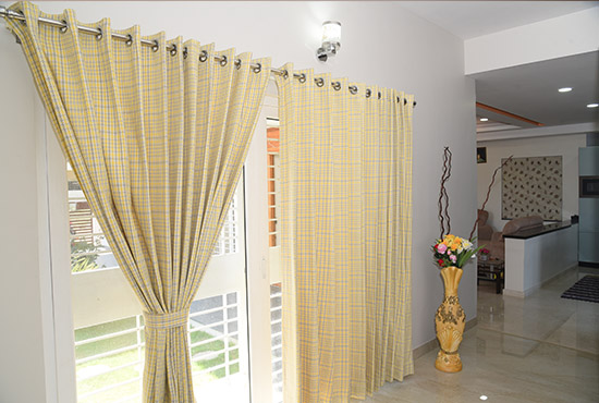 Yellow checked cotton curtains on an eyelet rod